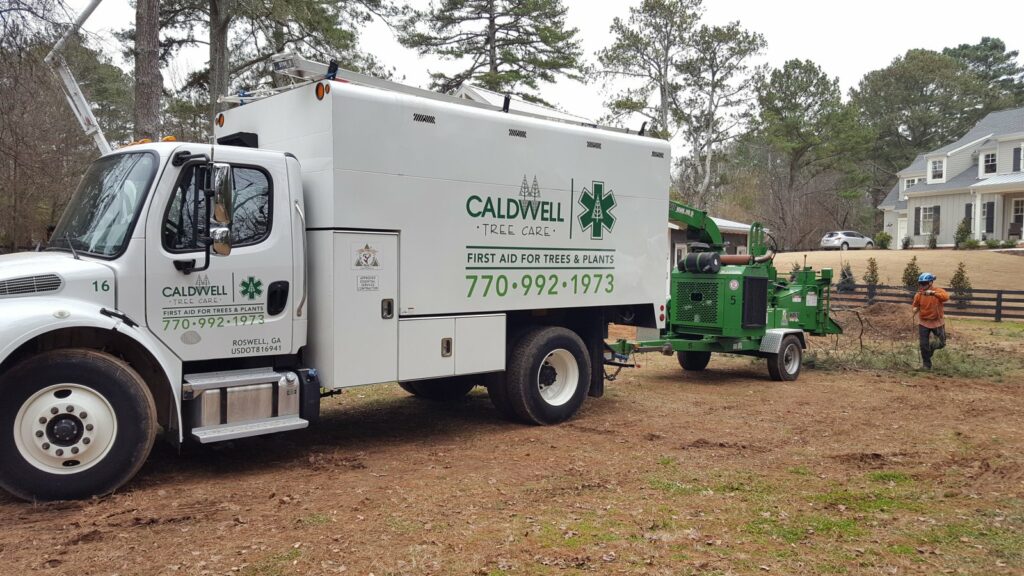 Caldwell Tree Care truck and chipper parked at job site